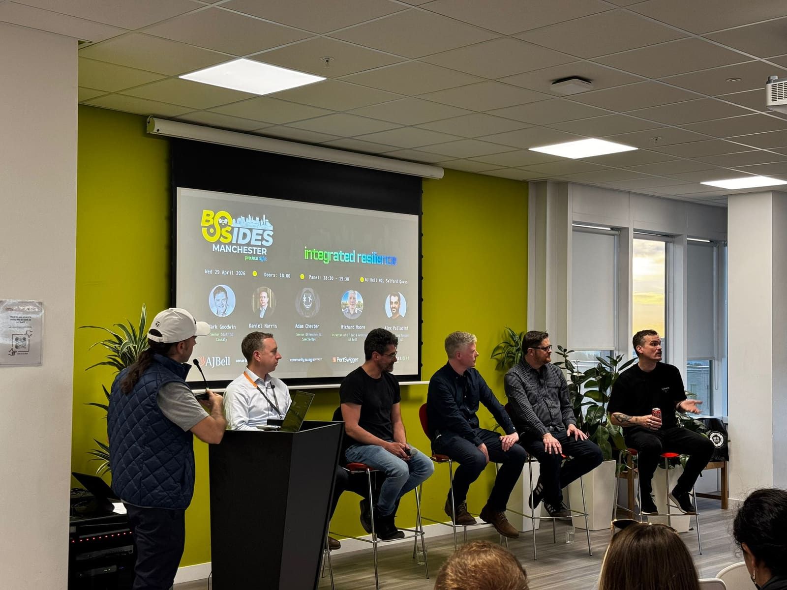 The integrated resilience panel during the preview night, panellists seated in front of the BSides Manchester slide