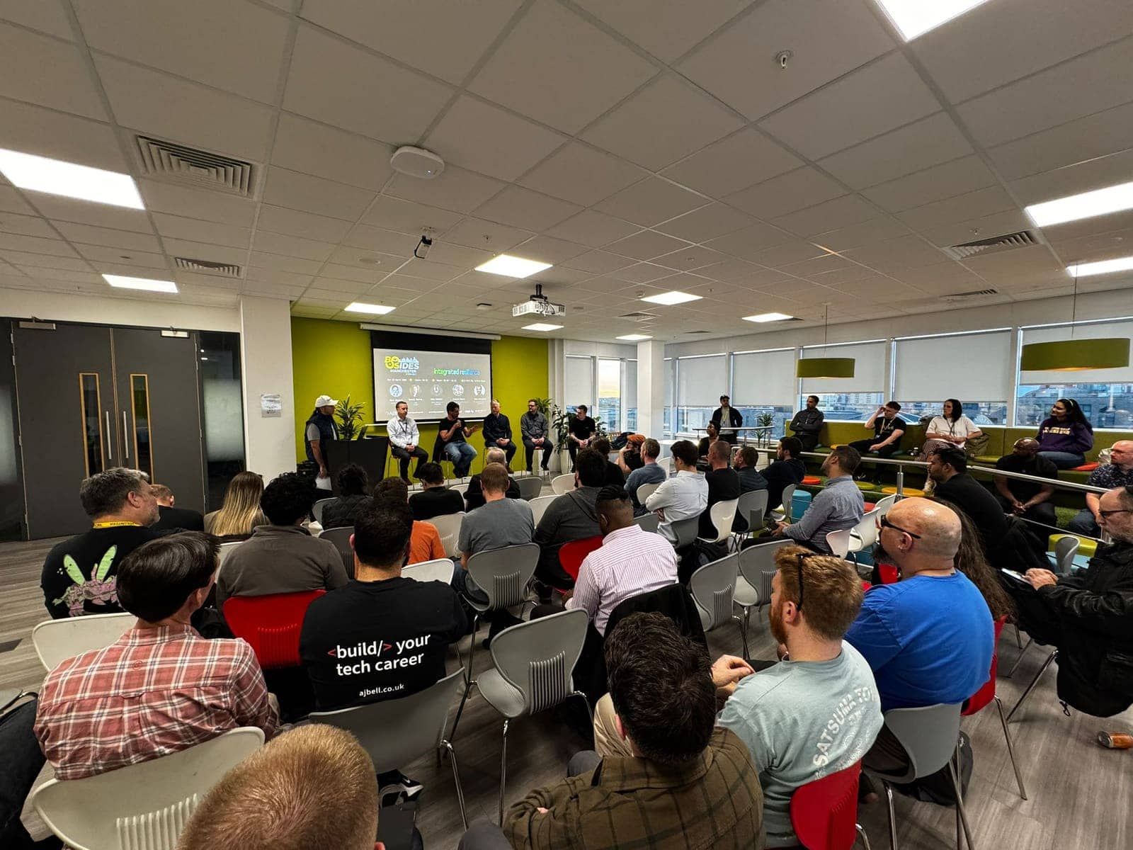 Audience seated for a panel discussion at the BSides Manchester preview night, AJ Bell HQ, Salford Quays